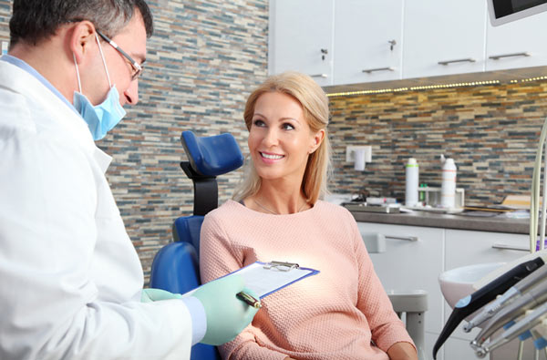 Woman talking to dentist before her teeth cleaning at Timothy H. Kindt, DDS in Mesa, AZ 